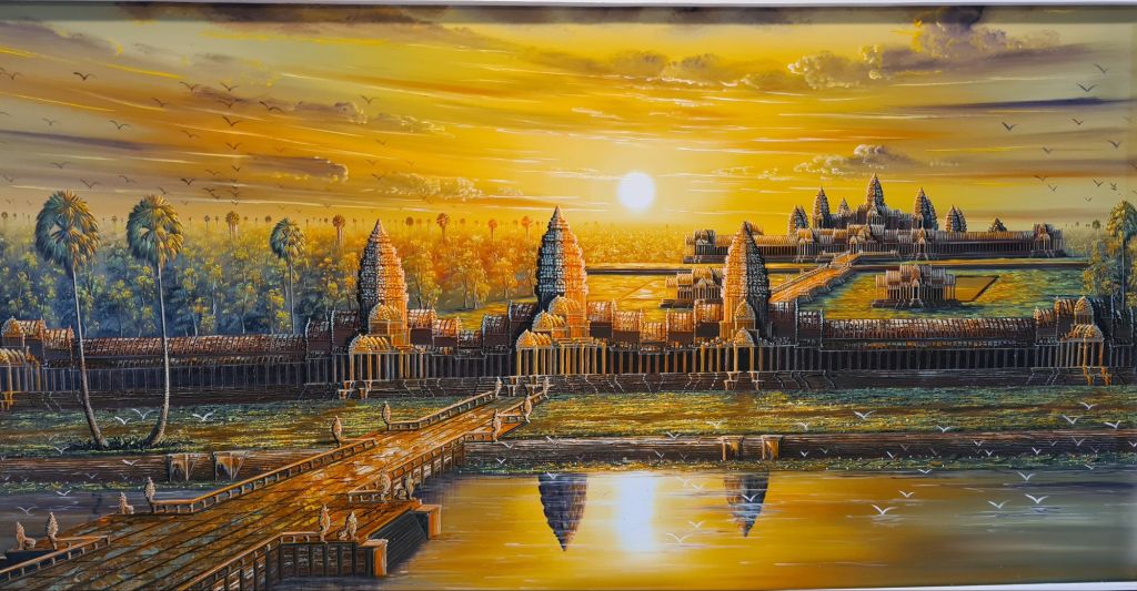 A vibrant sunset over a temple complex, featuring intricate architecture with tall spires, surrounded by lush greenery and a reflective body of water in the foreground.