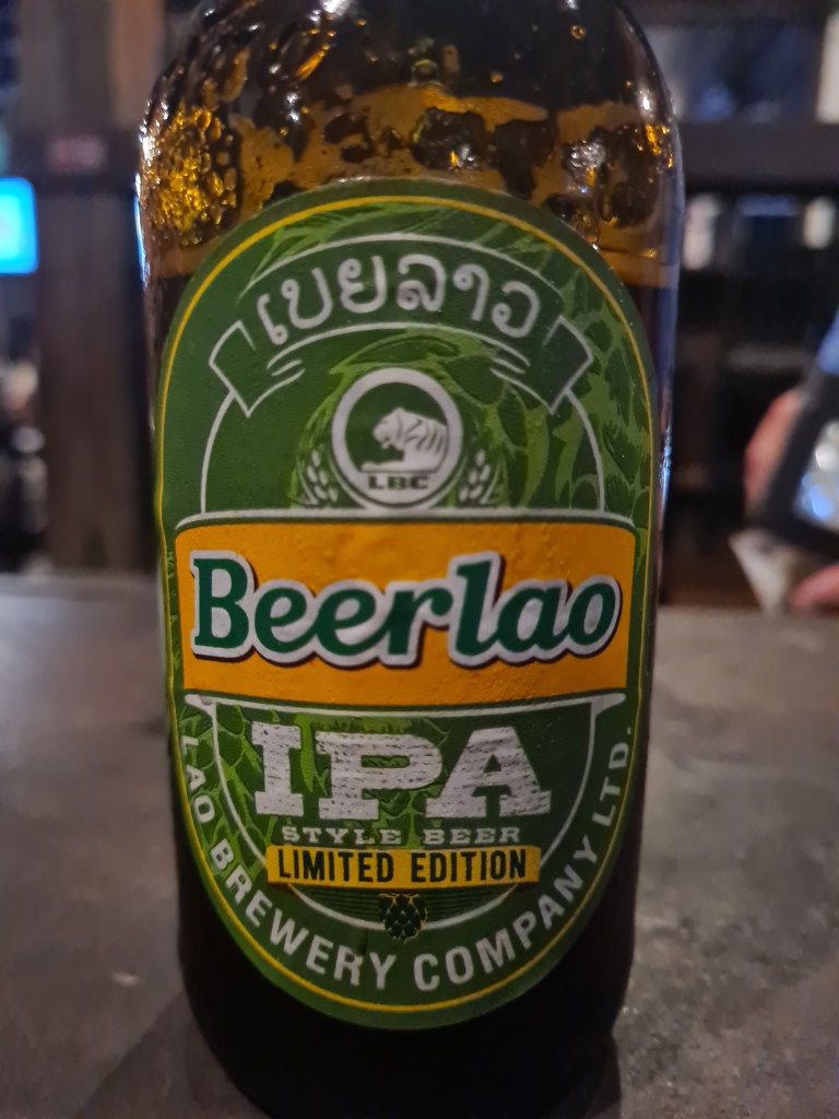 Close-up of a Beer Lao IPA limited edition bottle with a green label and logo.